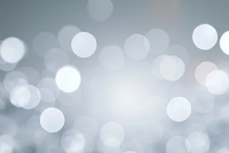 Abstract defocused background with scattered circular bokeh lights in soft white and gray tones