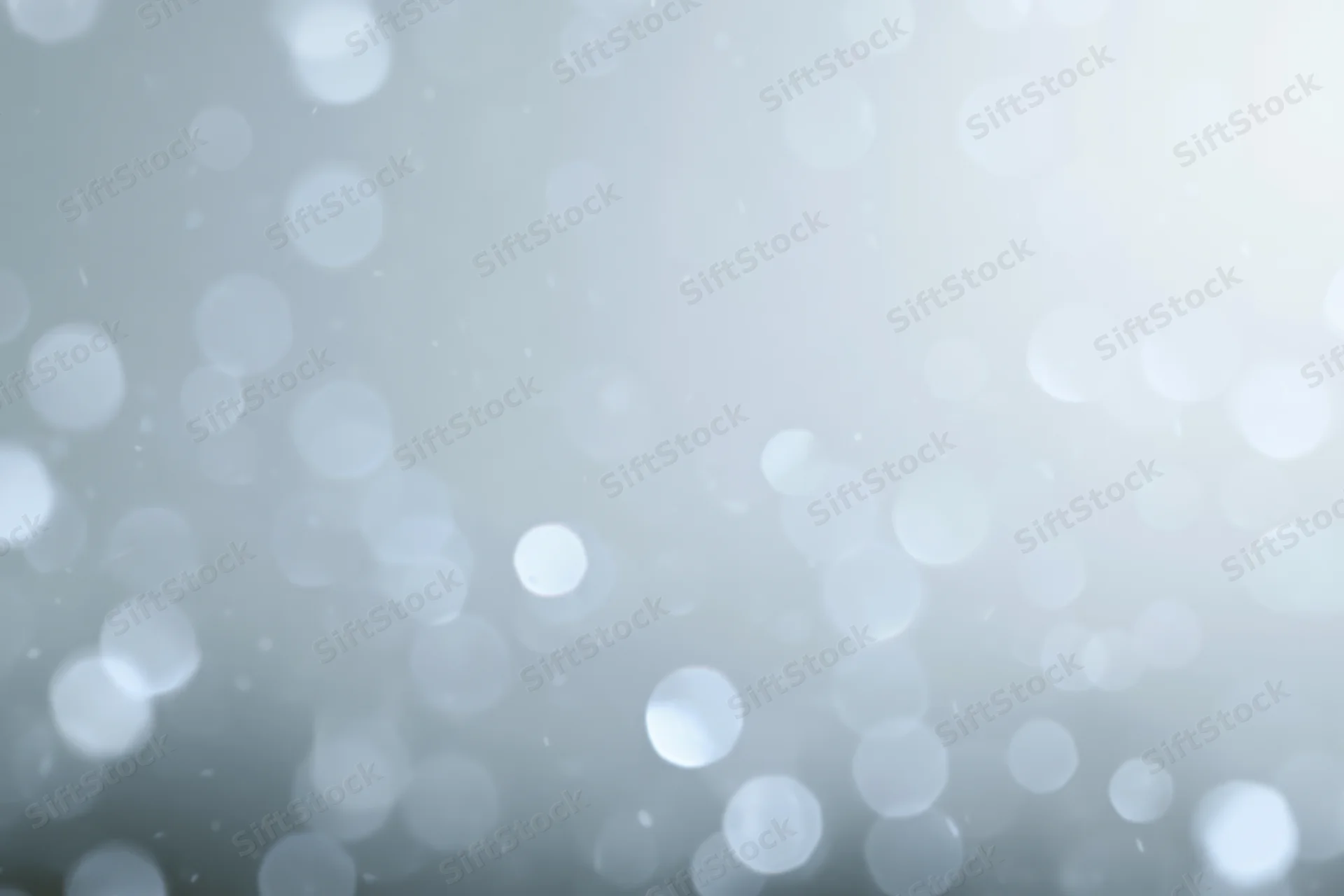 Abstract defocused background with scattered circular bokeh lights in soft white and gray tones