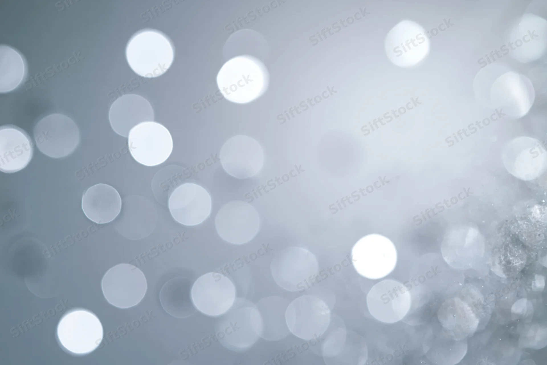 Abstract defocused background with scattered circular bokeh lights in soft white and gray tones