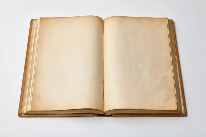 Open vintage hardcover book with blank yellowed pages on white background