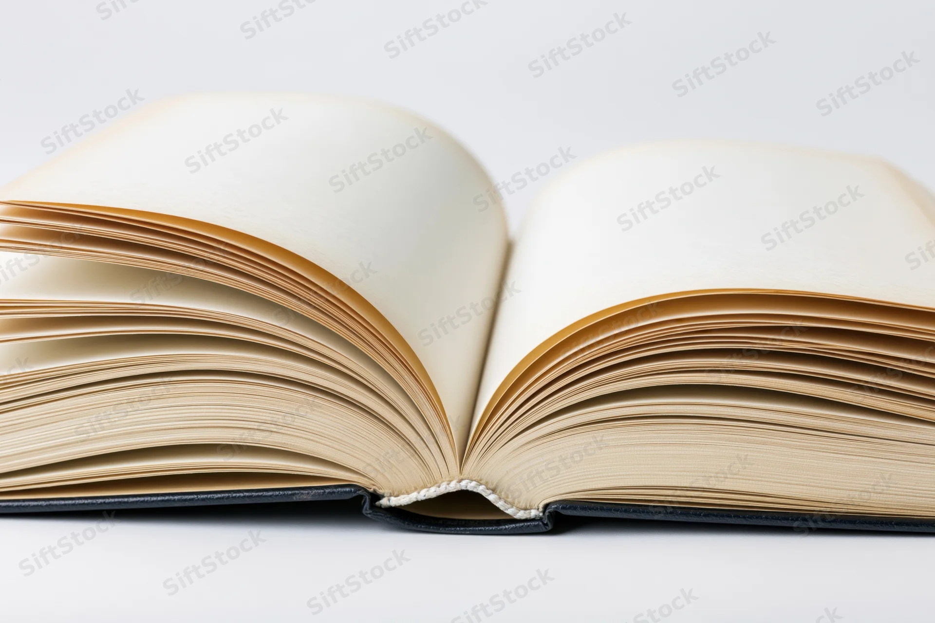 Open hardcover book lying flat with pages spread wide on white background