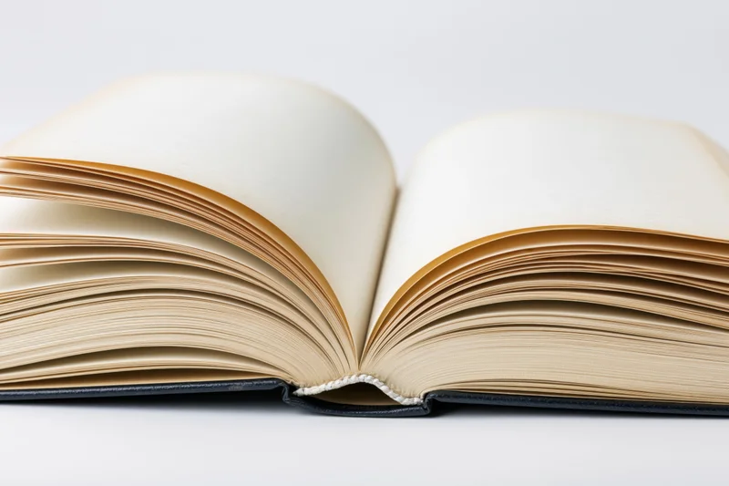 Open hardcover book lying flat with pages spread wide on white background