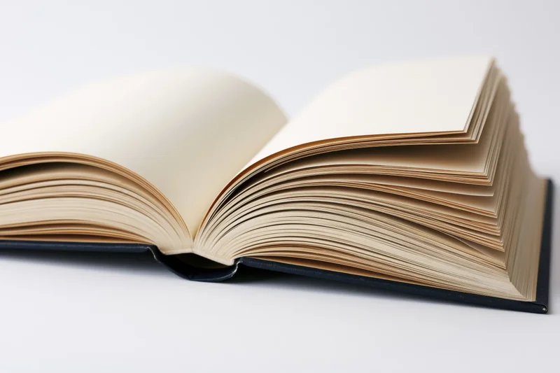 Open hardcover book lying flat with pages spread wide on white surface