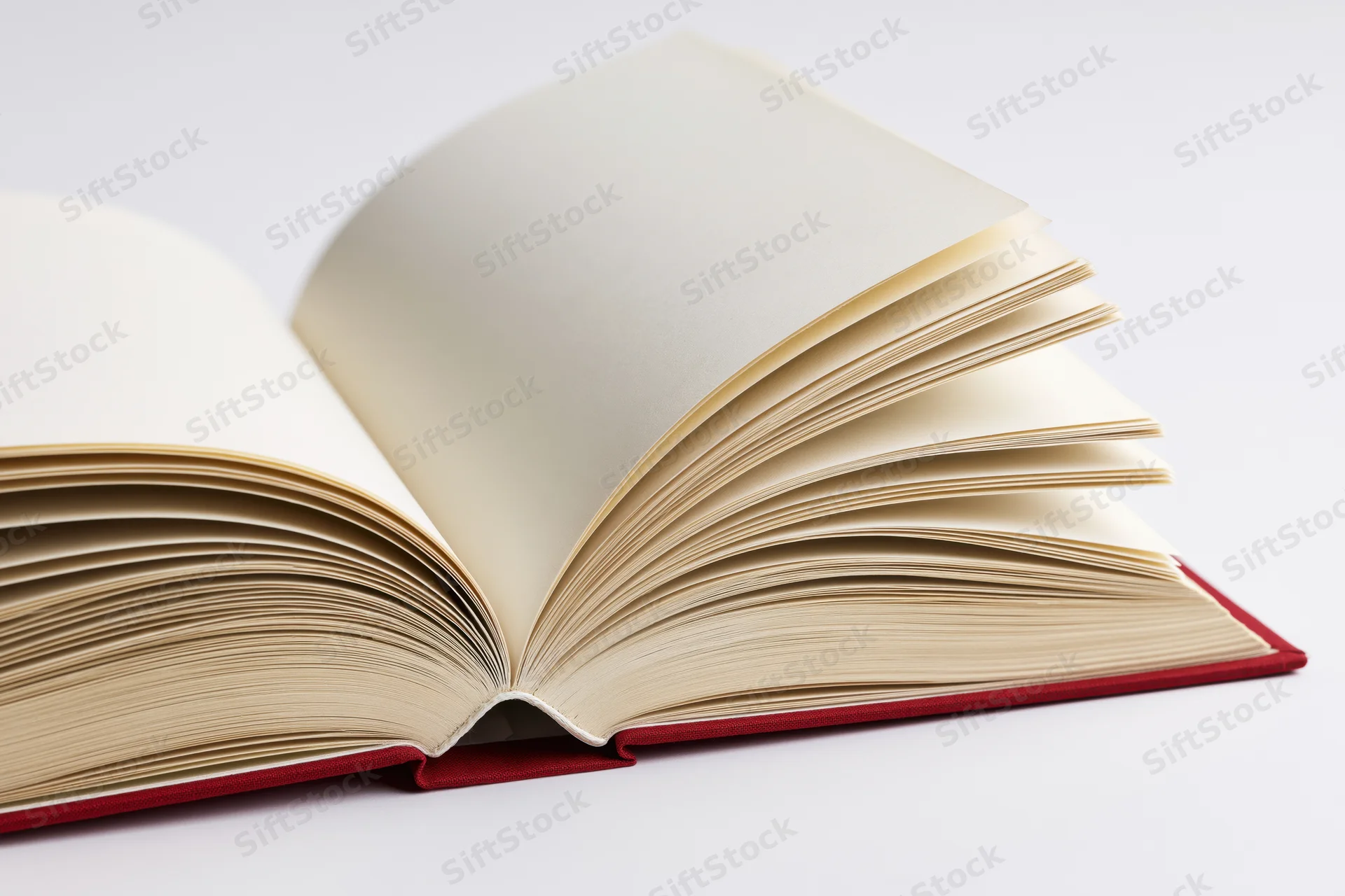 Open hardcover book with pages fanned wide on white background