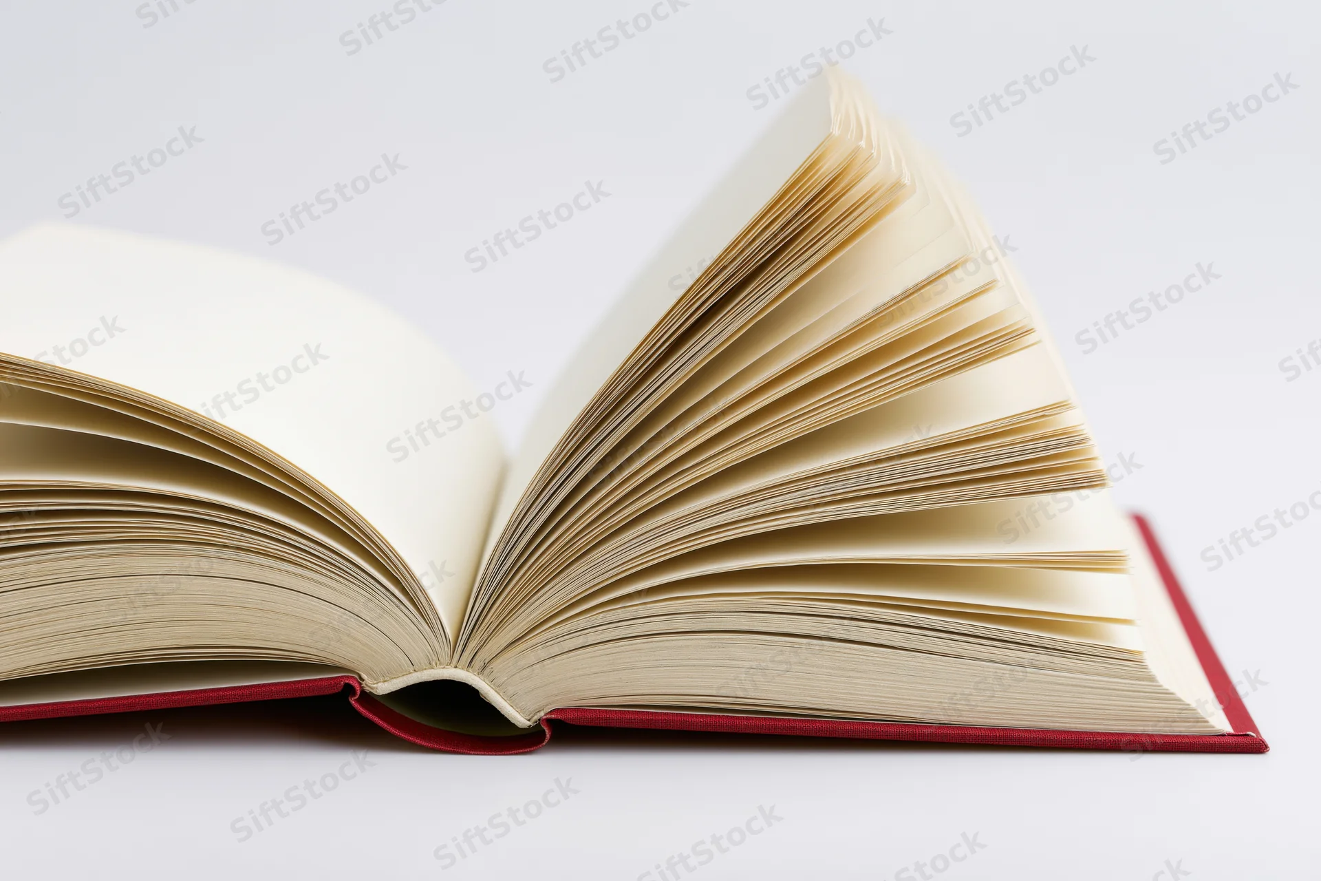 Open hardcover book with pages fanned wide on white background