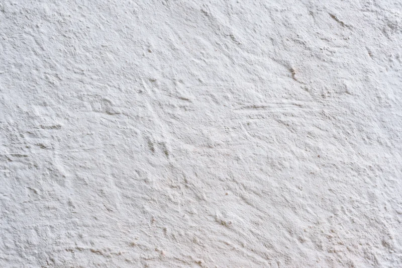 Close-up of a white plastered concrete wall with rough uneven texture