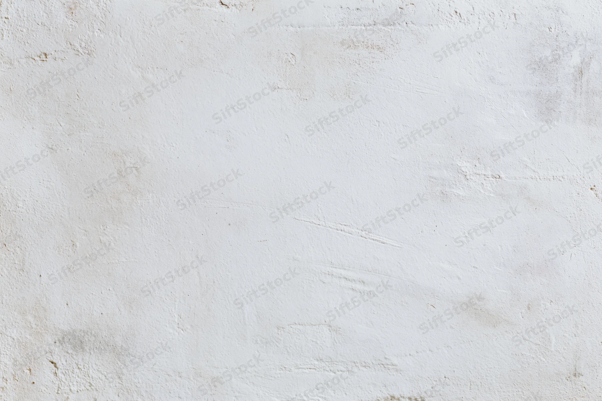White concrete wall with uneven plaster texture filling the frame