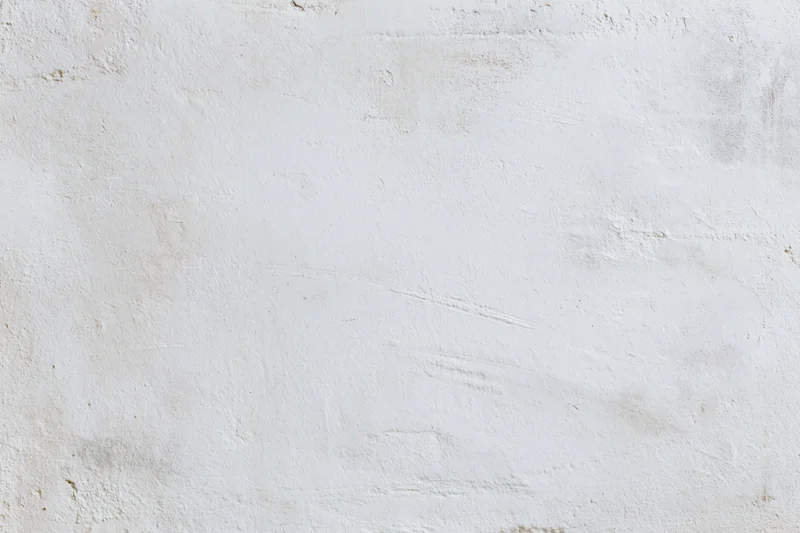 White concrete wall with uneven plaster texture filling the frame