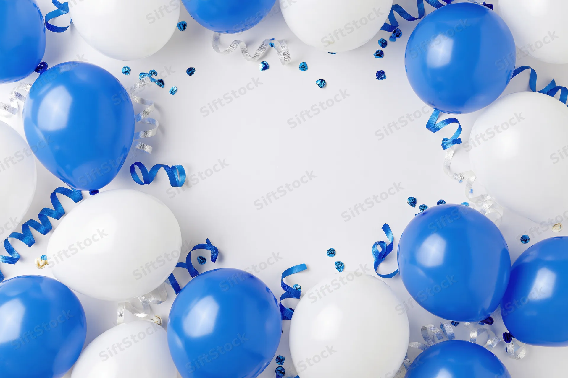 Blue and white balloons arranged in a border with confetti and streamers on a white surface, leaving copyspace in the center