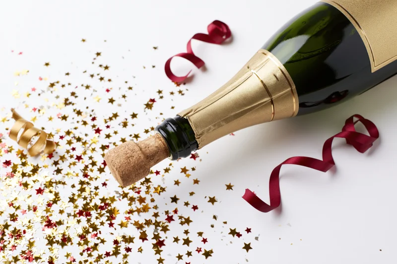 Champagne bottle popping open at an angle cork released