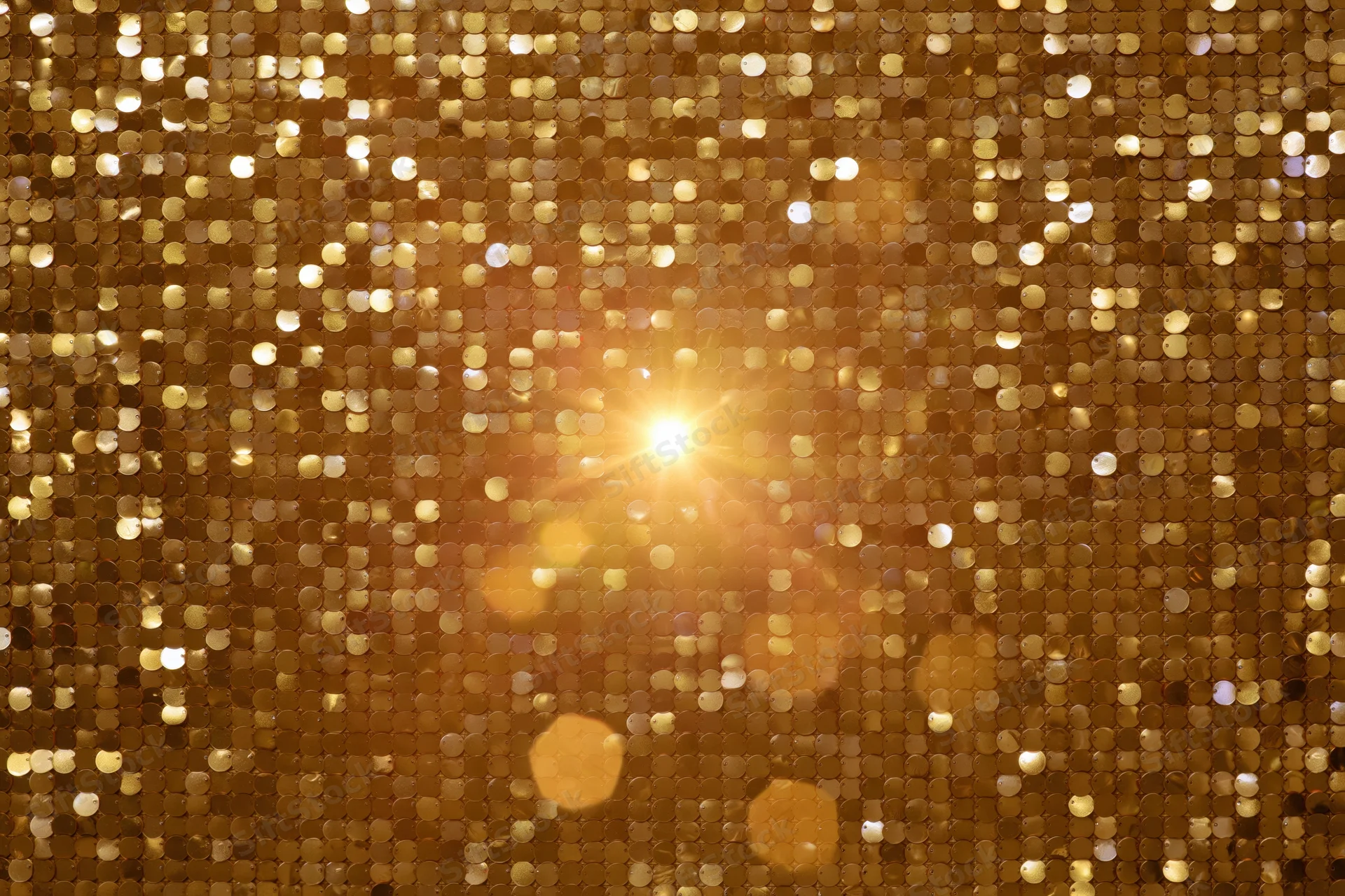 Close-up of gold sequin fabric with sparkling light reflections filling the frame
