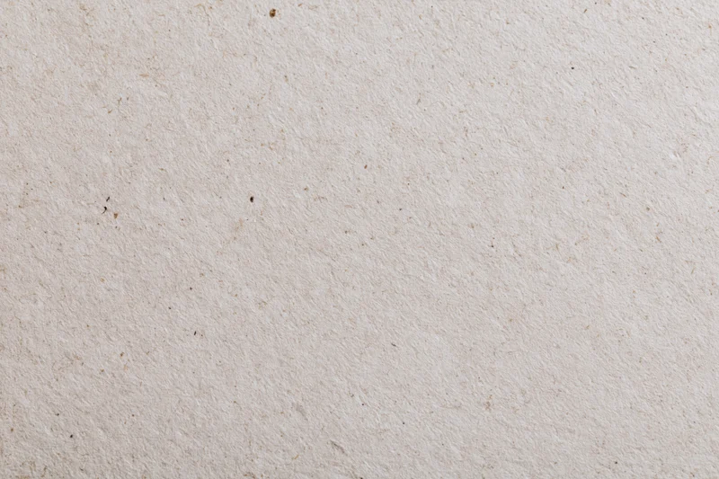 Close-up of a sheet of recycled kraft paper with visible fibers and natural texture filling the frame
