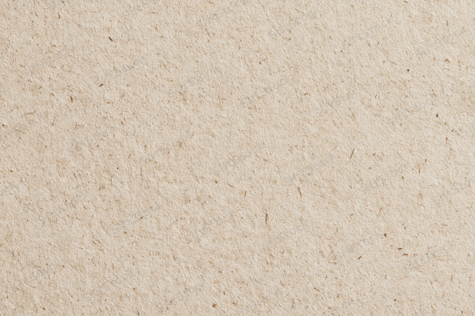 Close-up flat lay of a sheet of recycled kraft paper filling the frame with visible fibers and natural texture