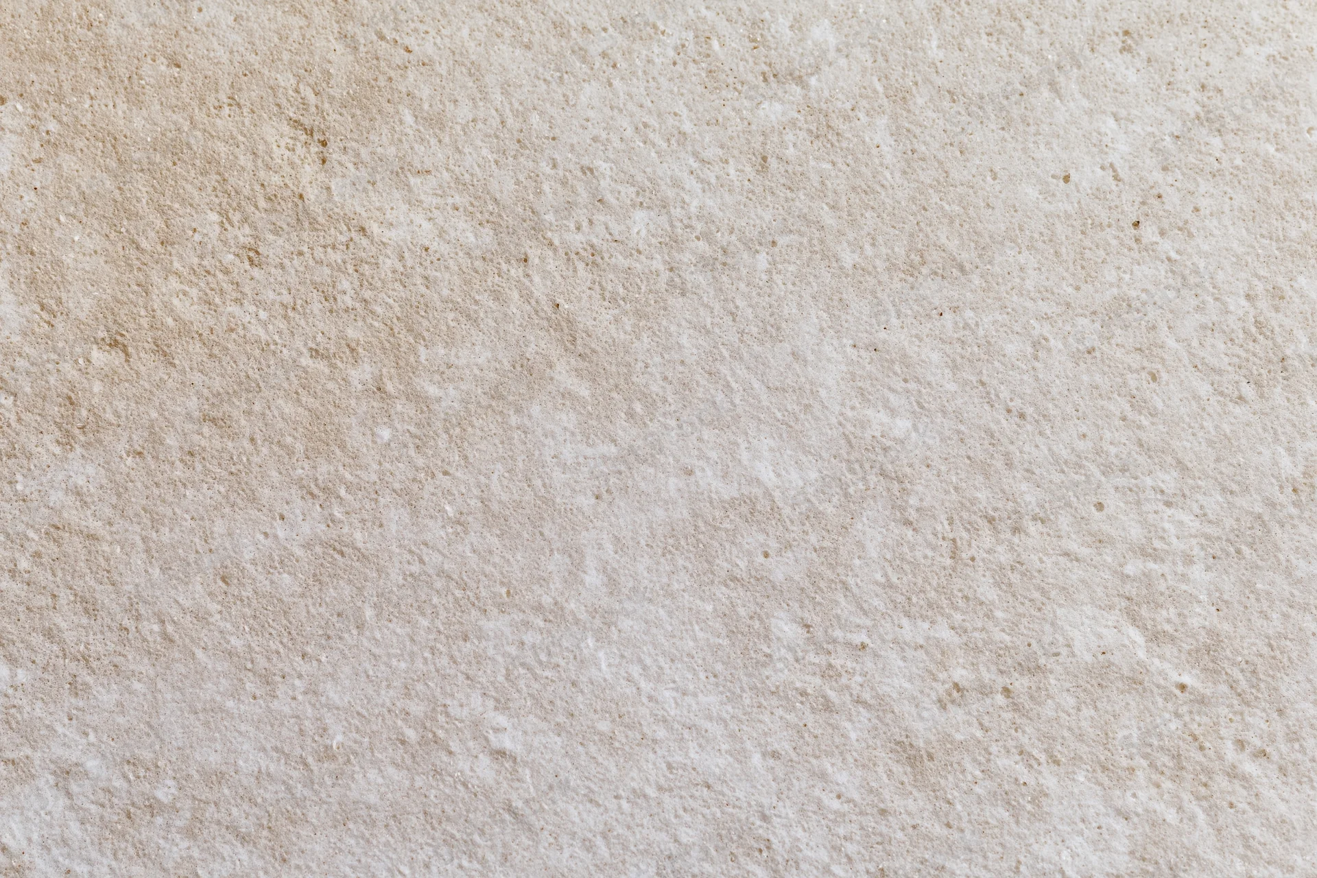 Close-up of smooth beige concrete wall surface with subtle texture and natural grain