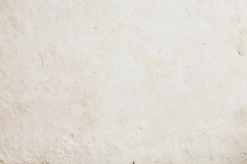 Close-up of a smooth beige plaster wall surface with subtle texture and natural imperfections