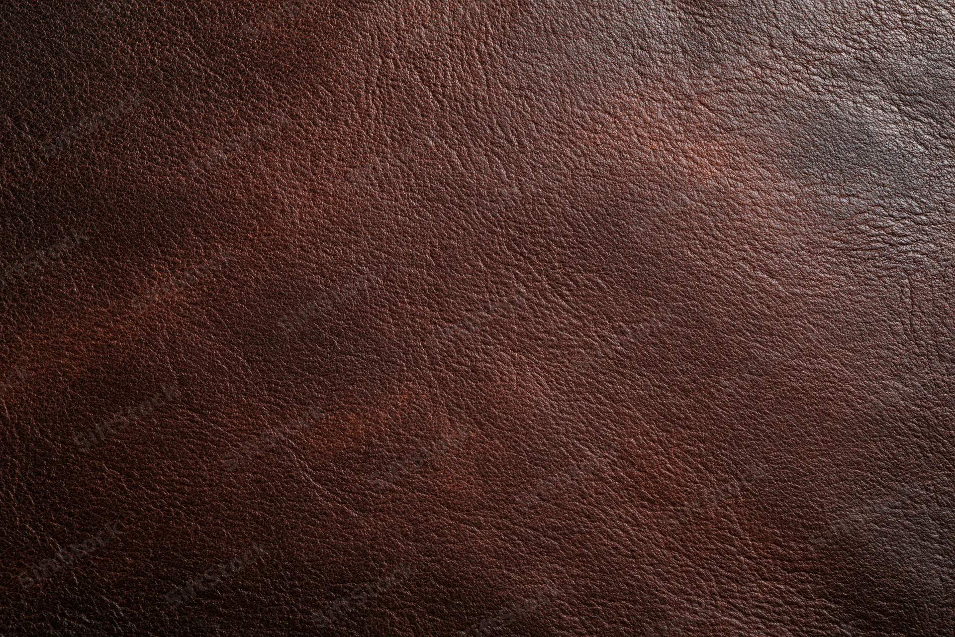 Close-up of aged dark brown leather surface with visible grain and texture