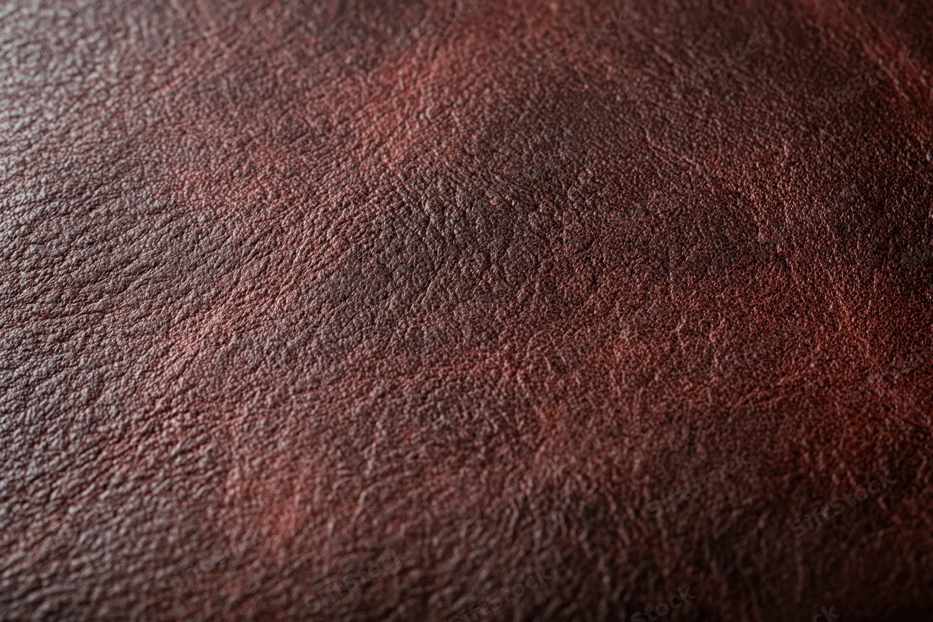 Close-up of aged dark brown leather surface with visible grain and texture