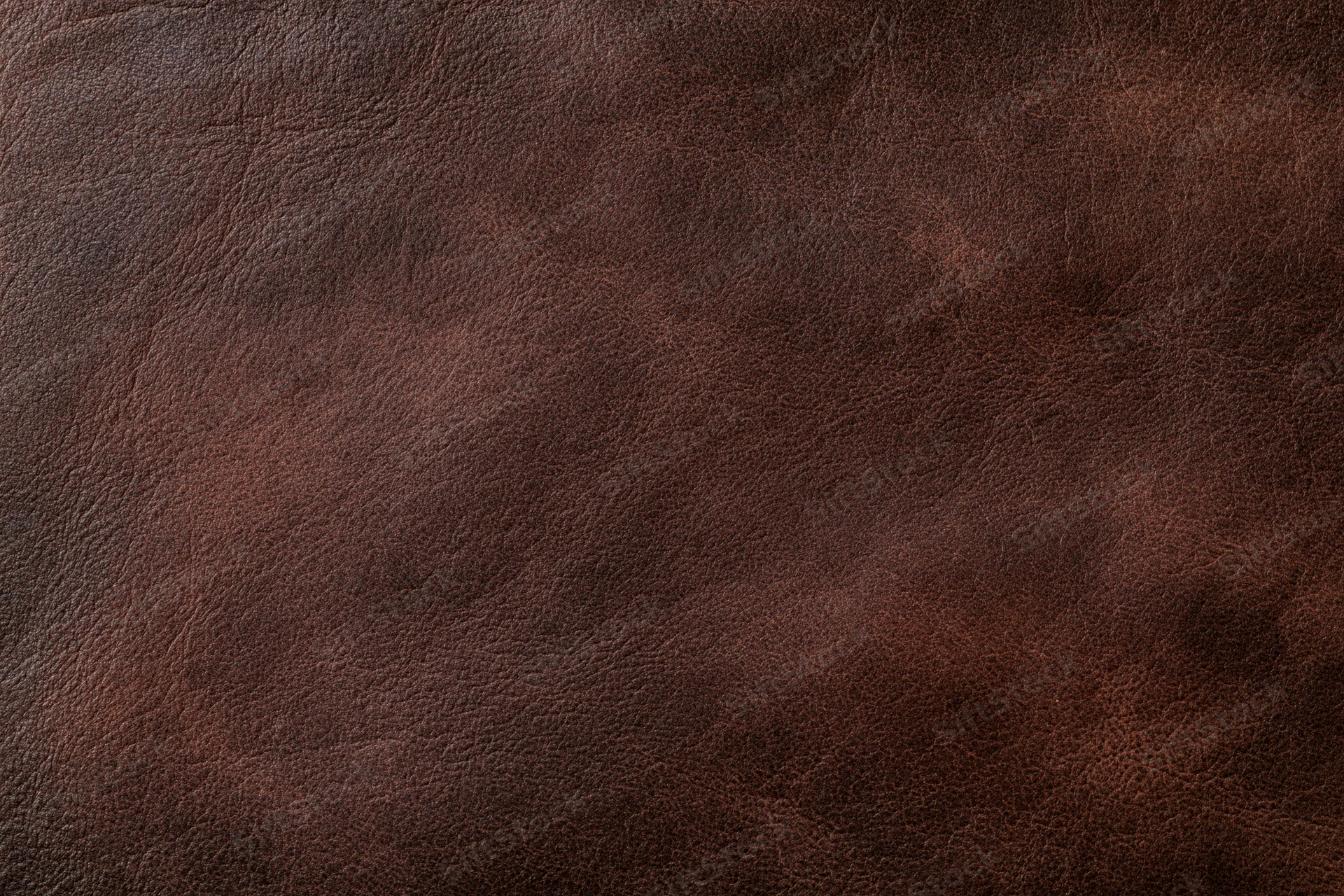 Close-up of aged dark brown leather surface with visible grain and texture