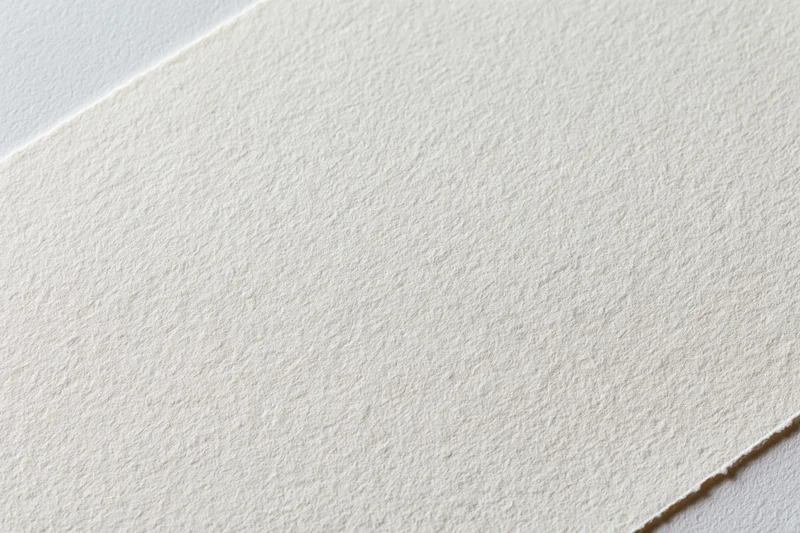 Close-up of plain white watercolor paper texture on a flat surface