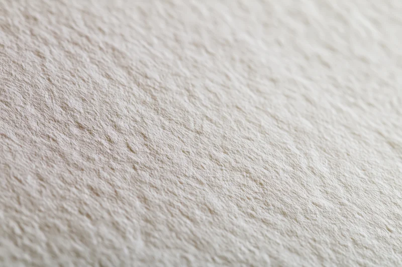 Close-up of white watercolor paper surface with textured grain in flat lay arrangement