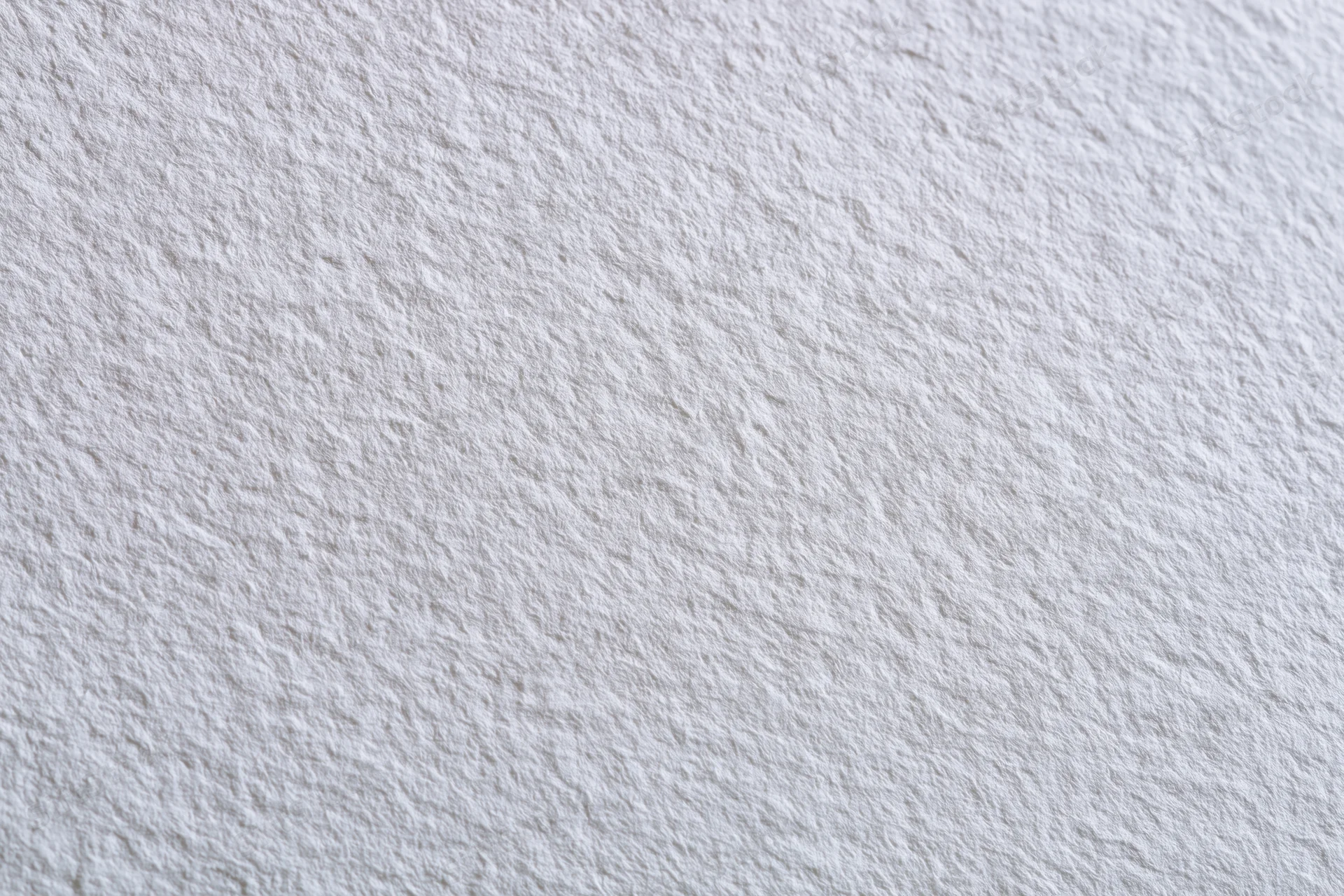 Close-up of white watercolor paper surface with textured grain filling the frame