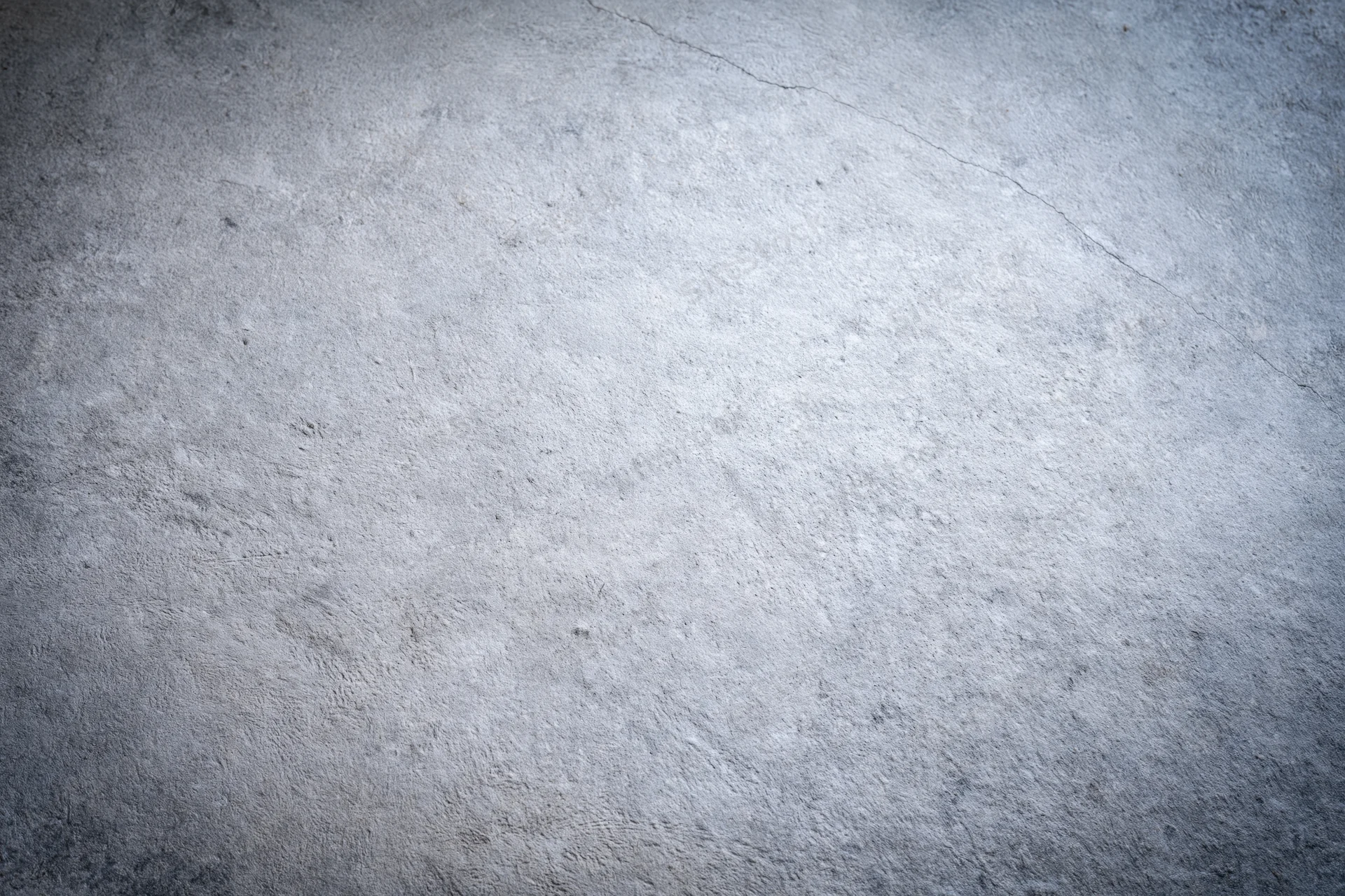 Close-up of a textured concrete wall surface with visible cracks and uneven finish