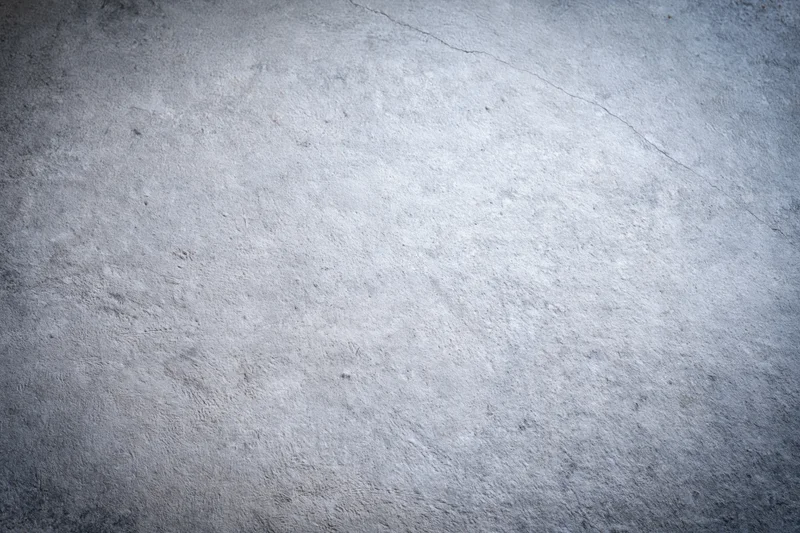 Close-up of a textured concrete wall surface with visible cracks and uneven finish