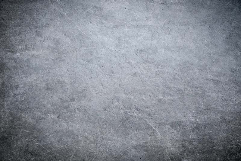 Close-up of a rough gray concrete wall surface with visible texture and subtle lighting variation