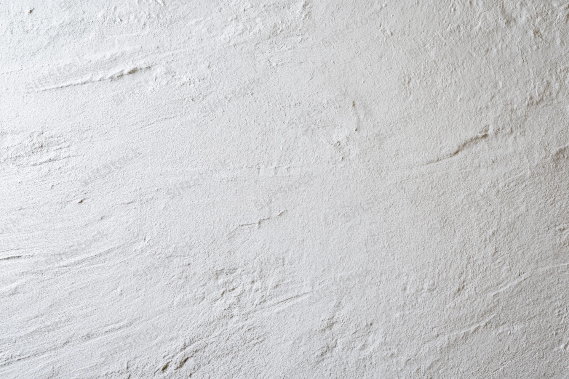 Close-up of white painted plaster wall surface with textured finish