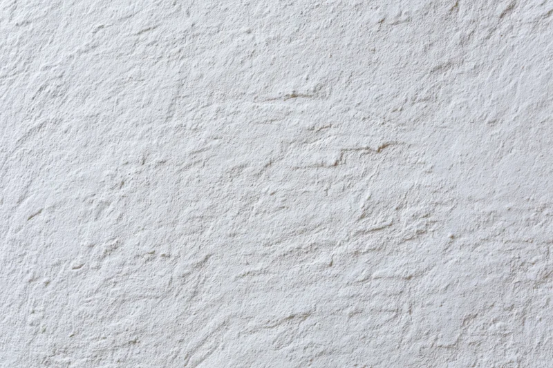 Close-up of white plaster wall surface with textured finish