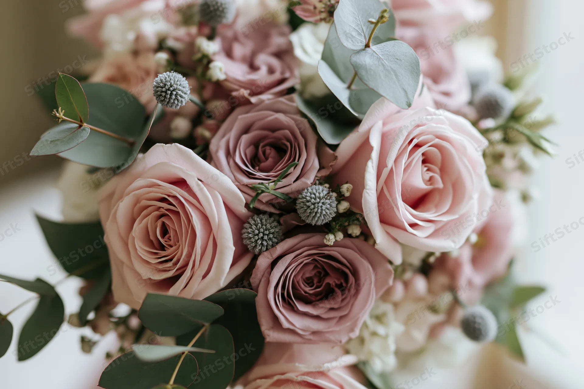 Close-up of a bridal bouquet with blush pink roses and eucalyptus greenery