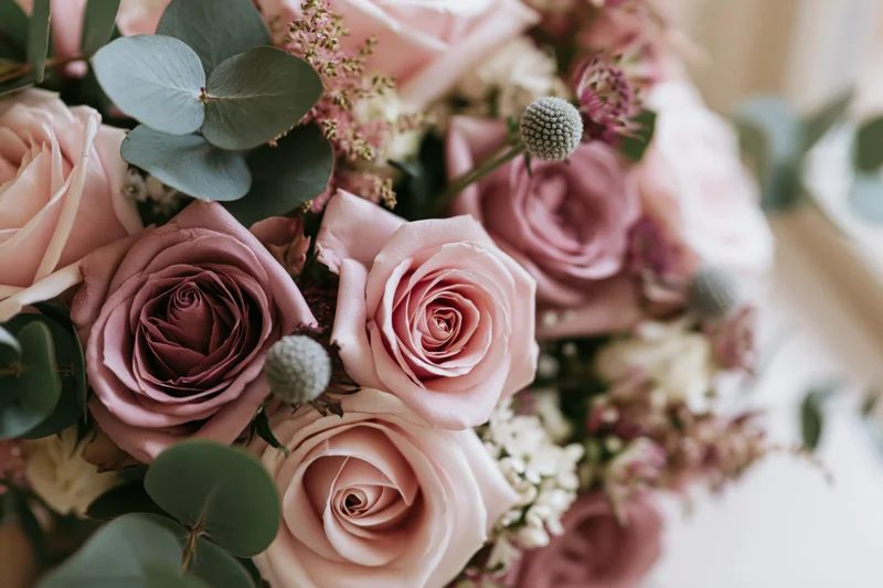 Close-up of a wedding bouquet with blush pink roses and green eucalyptus foliage