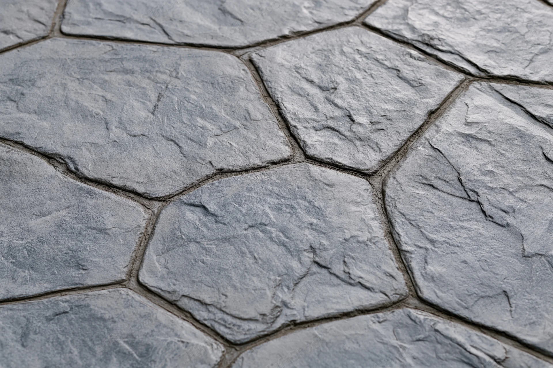 Close-up of stamped concrete pavement with irregular stone pattern and textured surface