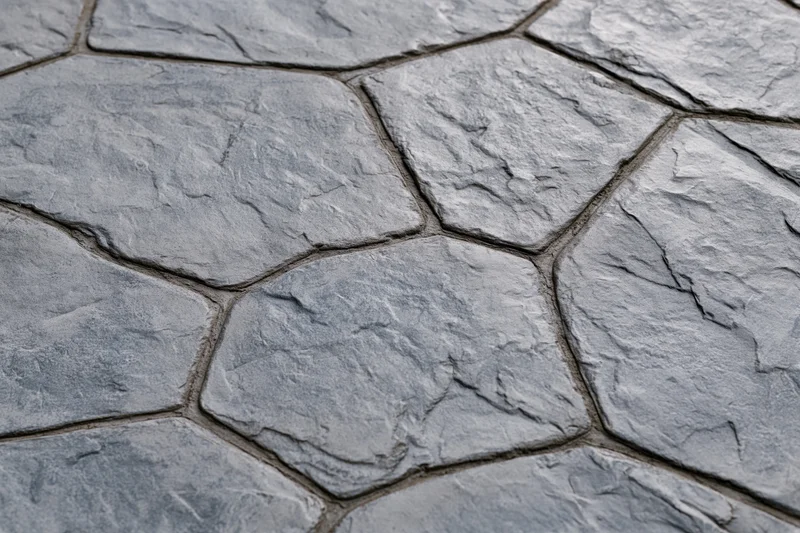 Close-up of stamped concrete pavement with irregular stone pattern and textured surface