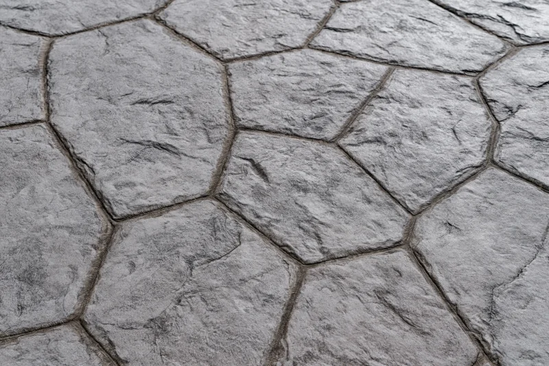 Close-up of stamped concrete pavement with irregular hexagonal pattern and textured surface