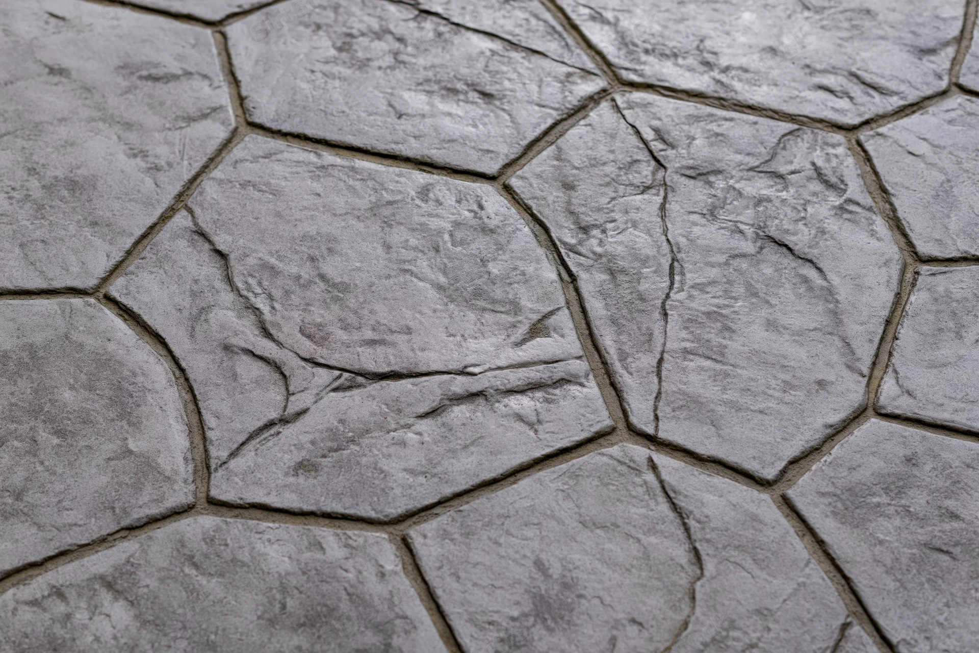 Close-up of stamped concrete paving with irregular stone pattern and textured surface