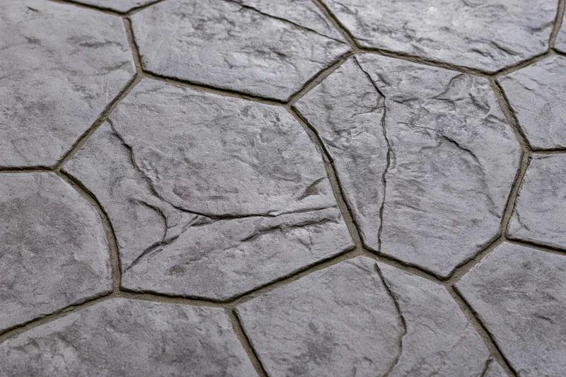 Close-up of stamped concrete paving with irregular stone pattern and textured surface