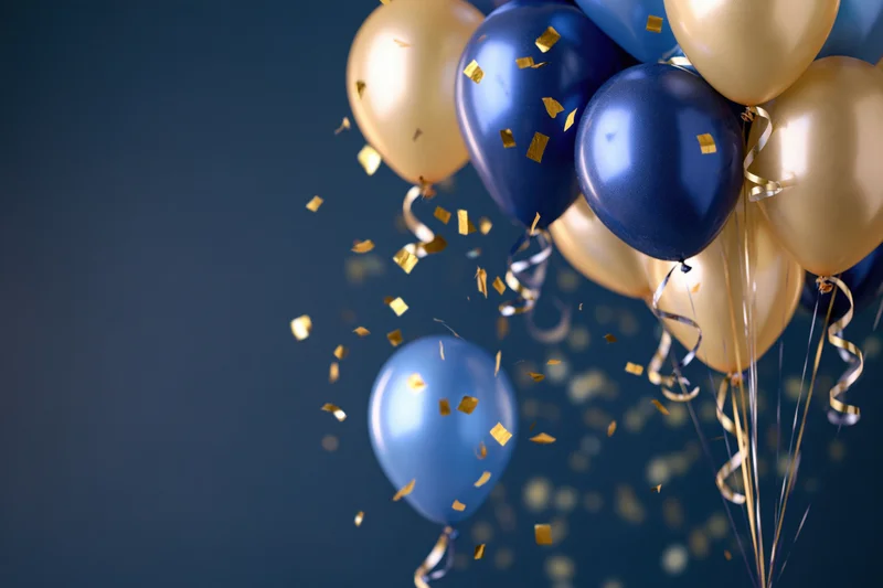 Cluster of metallic blue and gold balloons with falling confetti against dark blue background
