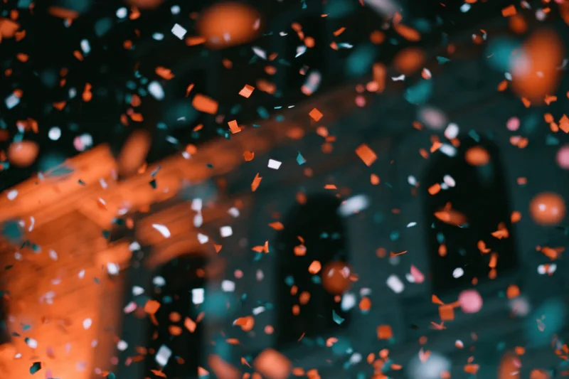 Colorful confetti floating in mid-air in front of a blurred building facade