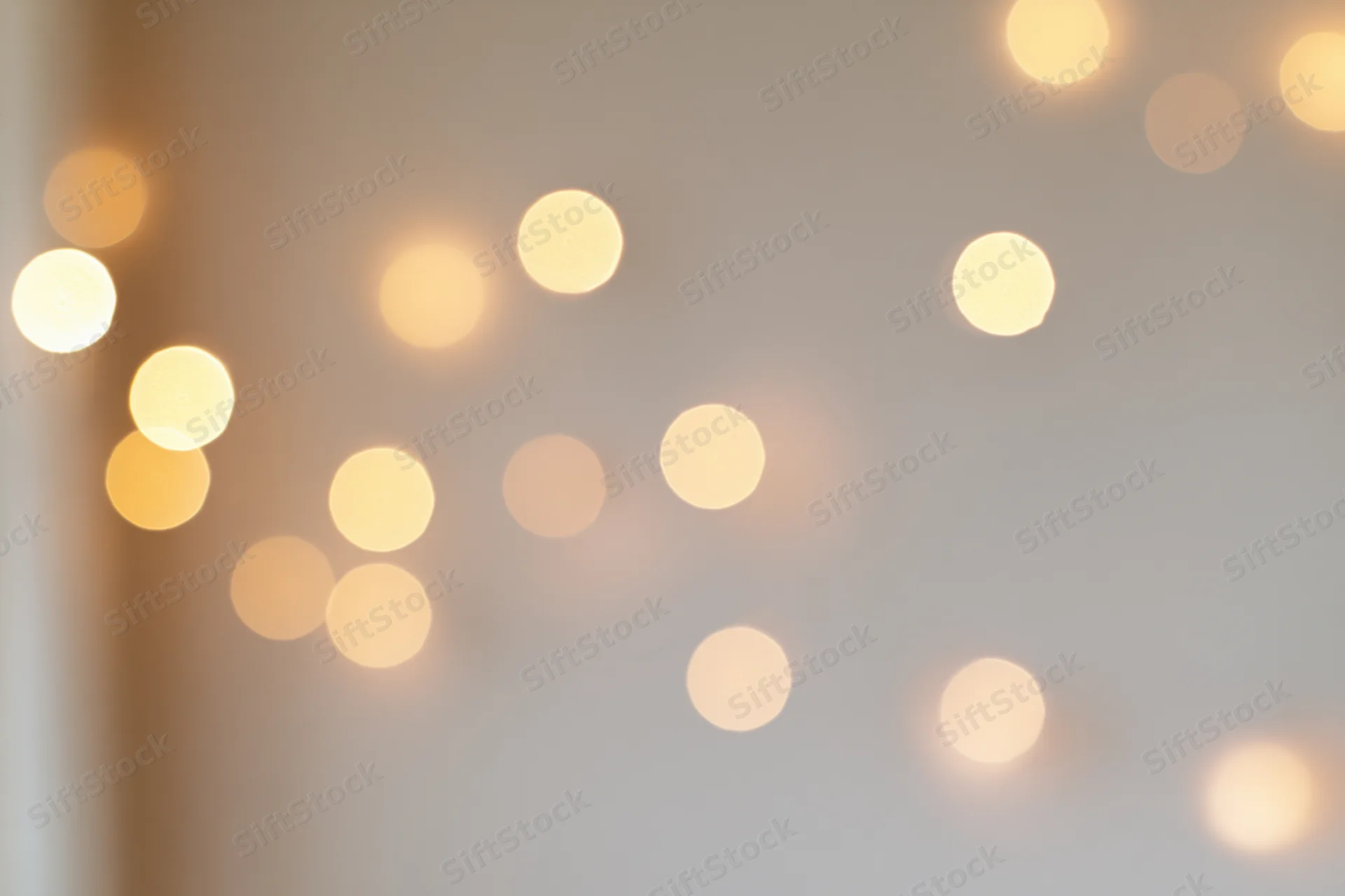 Warm glowing bokeh lights on a soft indoor wall background