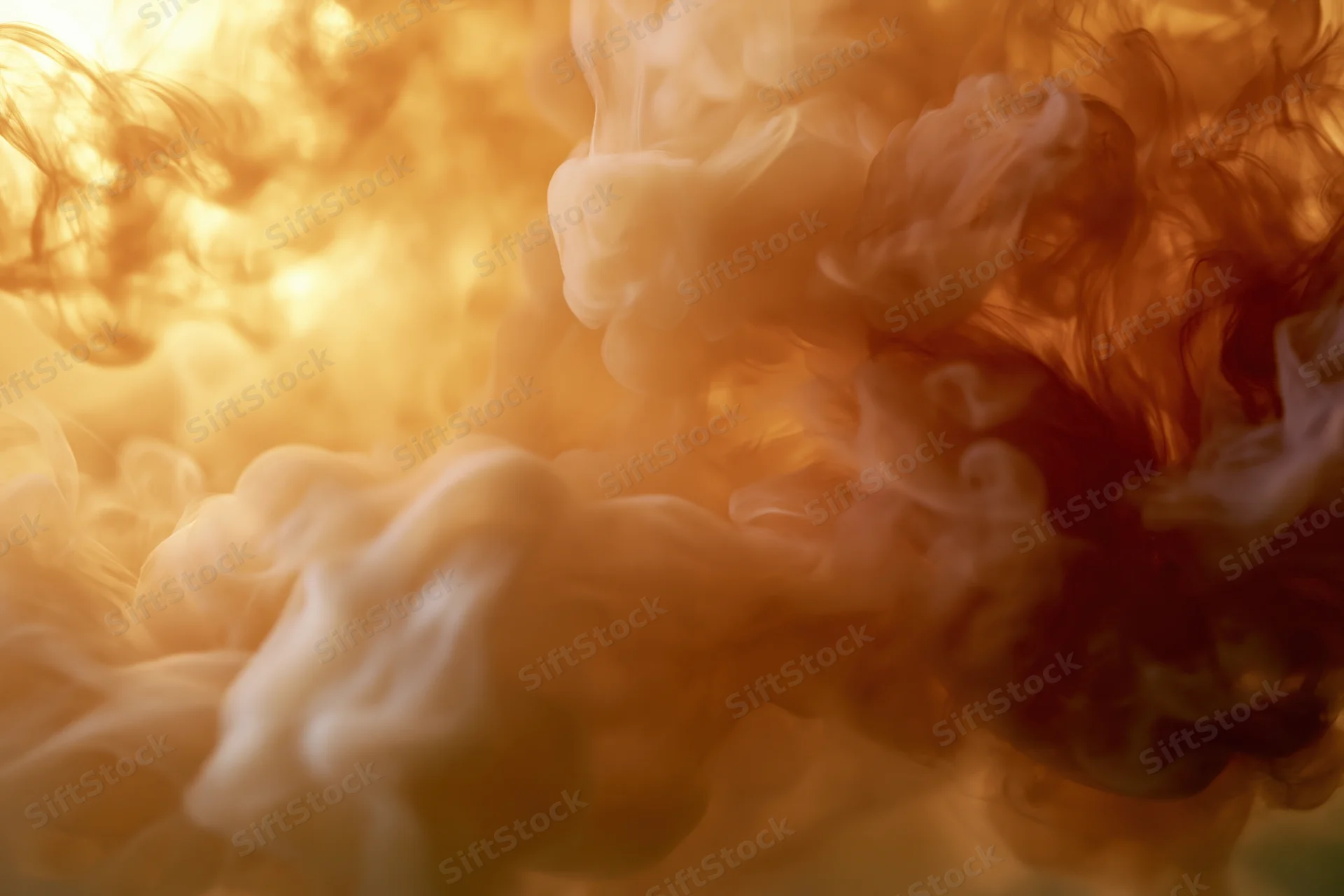 Swirling cream and amber ink dispersing in water against a warm glowing background