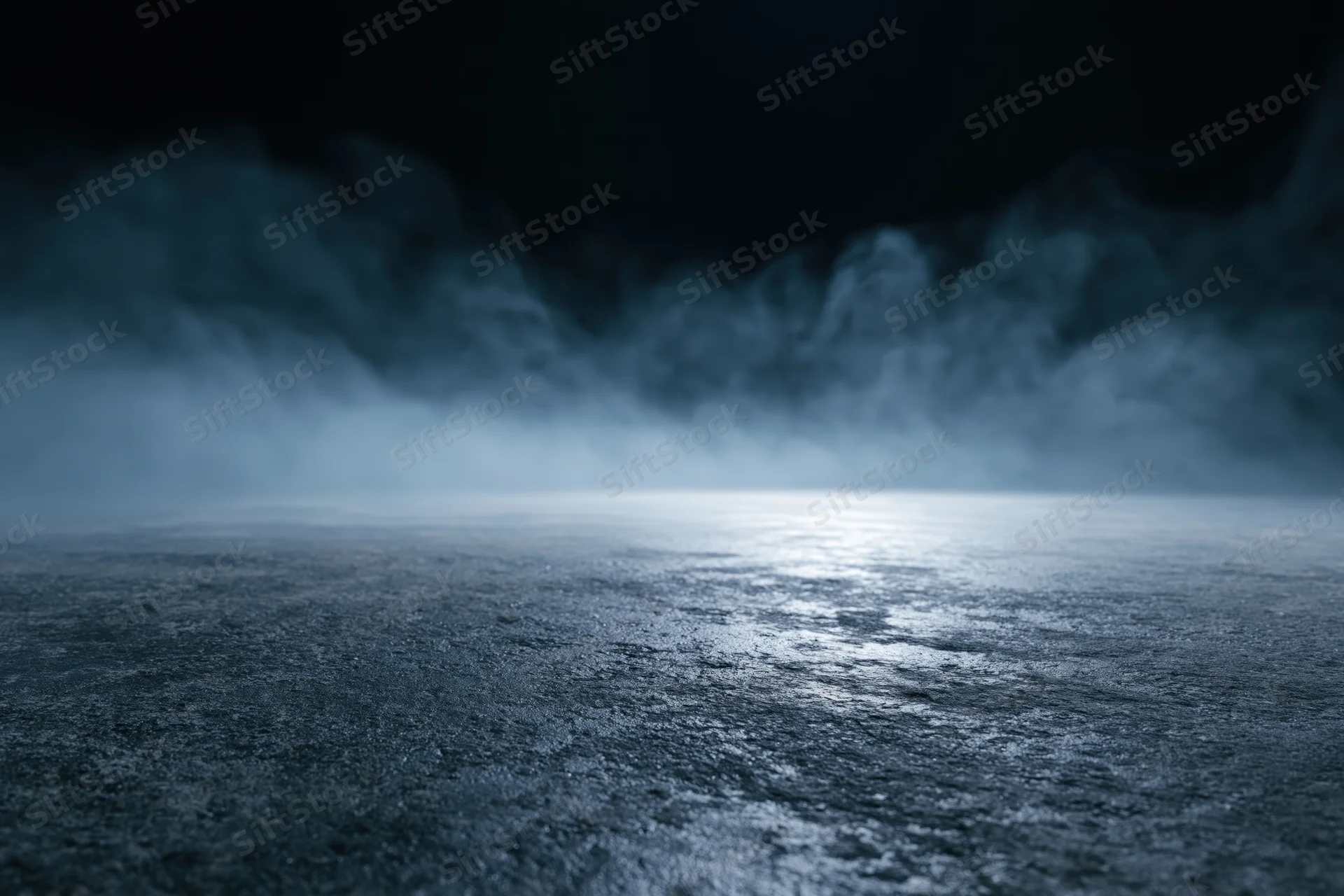 Dark industrial space with mist rising from wet concrete floor