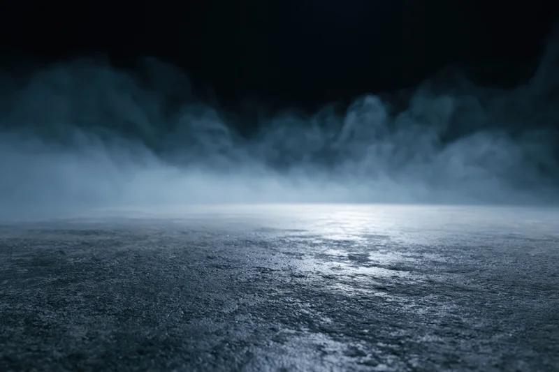 Dark industrial space with mist rising from wet concrete floor