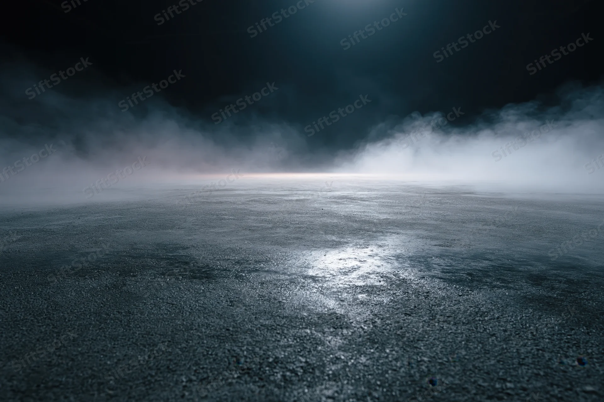 Dark industrial space with fog over wet concrete floor under spotlight