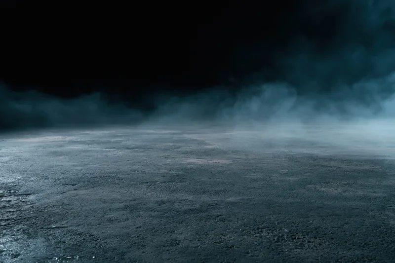 Dark concrete floor with low-lying smoke drifting across the surface