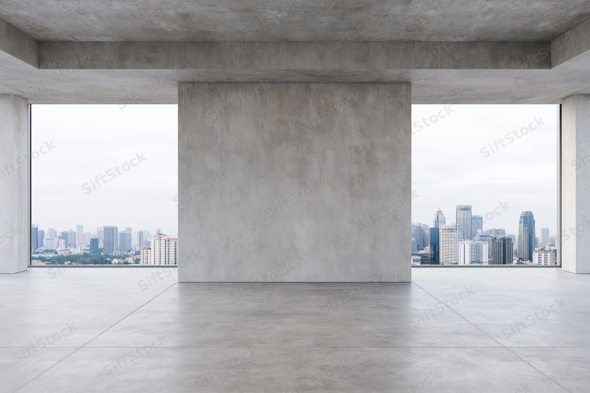Empty raw concrete room with large freestanding wall and city view through windows
