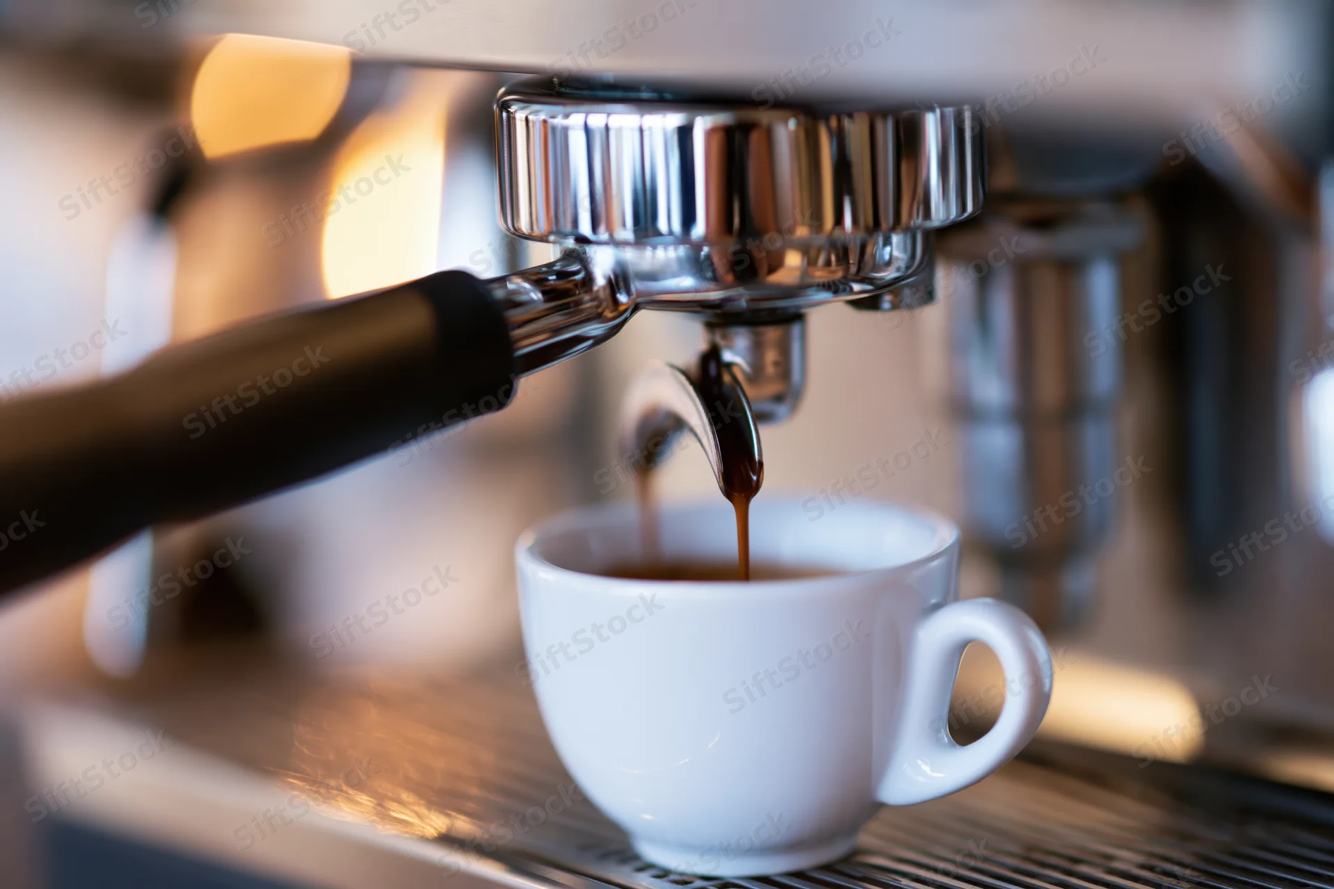 Espresso machine extracting coffee into a white ceramic cup on a drip tray