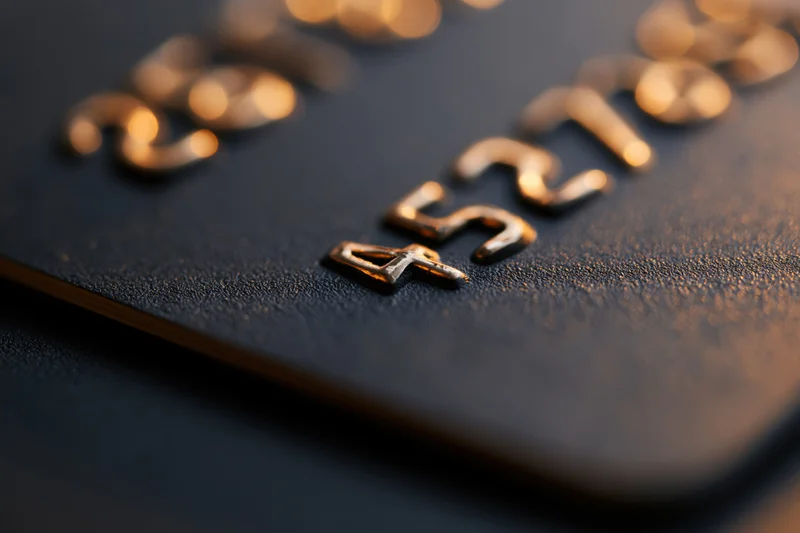 Close-up of embossed numbers on a black matte credit card surface