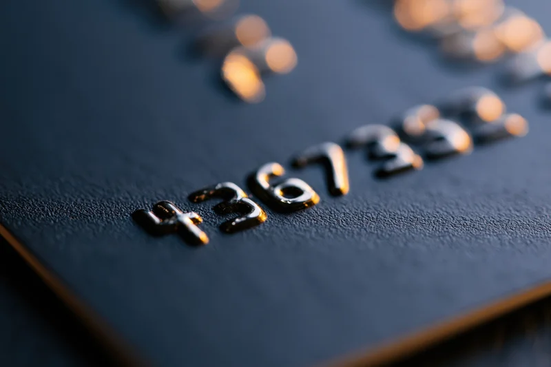 Close-up of embossed numbers on a black matte credit card surface