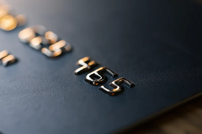 Close-up of embossed numbers on a black matte credit card surface